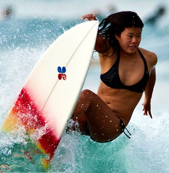 Generate an image of a beautiful Japanese girl who is a surfer. 